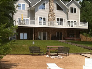 Sandy Shores (link) picture shows hot tun, patio, and steps how to the boat house and lake view at sunset.