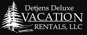 Detjens Deluxe Vacation Rentals, LLC (link to homepage) picture shows black background with white image of shoreline, water, canoe, pine trees